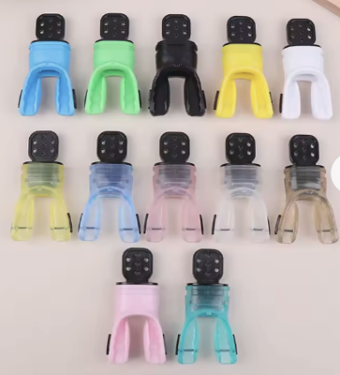 Variedad de clips de colores organizados en varias filas sobre una superficie clara.